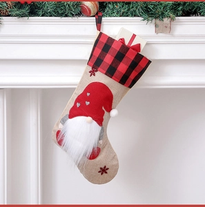 Close-up of linen Christmas stocking with gnome motif hanging on a white fireplace