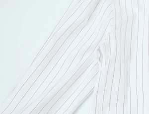 Detail view of vertical stripes and high-quality stitching on the white shirt sleeve