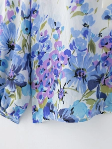 Detailed close-up of chiffon floral fabric with blue and purple blooms on long sleeve