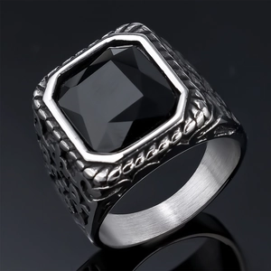 Close-up of men's vintage stainless steel ring with square black gemstone and carvings