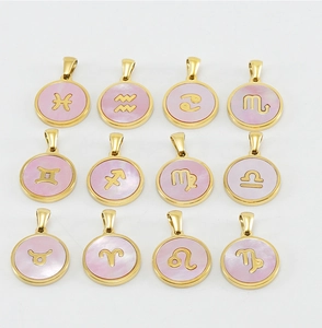 Draufsicht auf zwölf goldene Sternzeichen-Anhänger mit rosa Perlmutt-Inlays und Symbolen