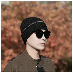 Close-up of black ribbed knit beanie with grey stripes and warm fleece lining