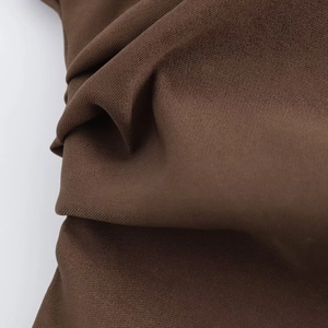 Macro shot of brown sleeveless top fabric showing pleated texture and knit quality