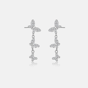 Detailed macro of silver butterfly dangle earrings featuring sparkling white zircon accents