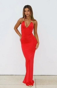 Close-up of elegant deep V-neckline with decorative gold metal rings on a red dress