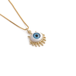 Detailed close-up of a gold chain necklace with a blue evil eye pendant and gold lashes