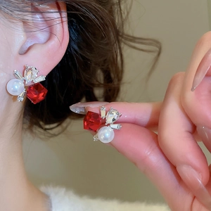 Detailed close-up of square red crystal earrings with pearls and silver accents