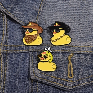 Lot de pins canard en émail avec lunettes et chapeaux sur une veste en jean