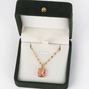 Detail of pink rectangular gemstone pendant necklace in a luxury green velvet jewelry box