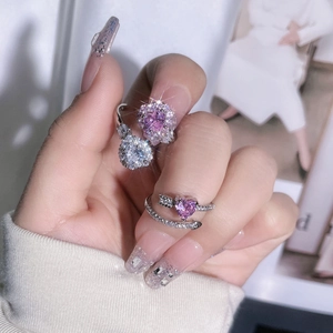 Detail of pink heart-shaped crystal ring set with arrow design and pavé diamonds