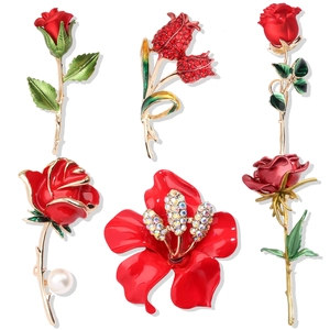 Set of six elegant red rose and camellia brooches with rhinestones and pearls on white