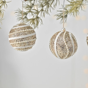 Golden Christmas foam balls with sequins and white pearls hanging on a festive tree