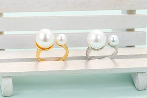 Minimalist adjustable open rings with faux pearls in gold and silver finish on display
