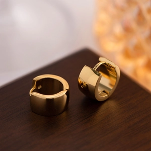 Macro shot of 18K gold plated stainless steel huggie earrings with polished finish
