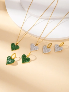 Detail von Gold Titan Herz Schmuckset mit grünen und klaren Zirkonia Steinen