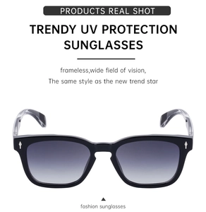 Close-up of black sunglasses with silver arrow rivets and grey gradient lenses