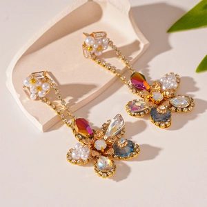 Detail of luxury flower earrings with pearls and colorful crystals on stone base
