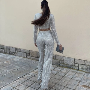 Close-up back view of silver sequin fringe top and wide-leg trousers party set