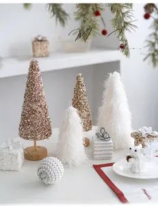 Detail view of mini champagne Christmas trees and plush bear in a festive desktop setting