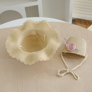 Detail of straw hat and matching crossbody bag with pink flowers for little girls