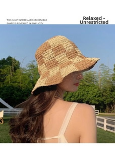 Outdoor close-up of a khaki checkered straw bucket hat with a stylish wavy brim texture