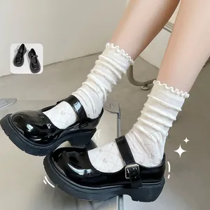 White ruffle cotton mid-tube socks paired with black patent leather Mary Jane shoes