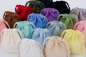 Stack of colorful drawstring canvas storage bags in various vibrant fabric colors