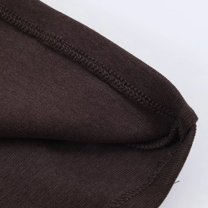 Gros plan détaillé du tissu en maille marron foncé avec finition ourlet à double couture
