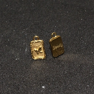 Gold butterfly engraved rectangle pendant necklace with Beauty lettering on metal surface