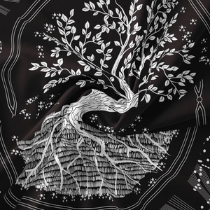 Macro shot of folded black bohemian tapestry showing detailed Tree of Life and star patterns