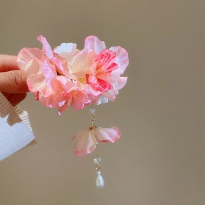 Détail d'une pince à cheveux fleur rose dégradé avec pétales en soie et pompon perle