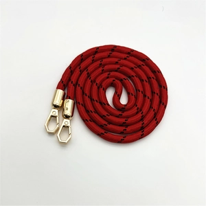 Dettaglio tracolla intrecciata rossa con moschettoni in metallo dorato su bianco