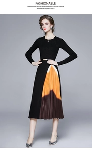 Détail de robe en tricot ajustée avec jupe plissée dégradée et ceinture dorée