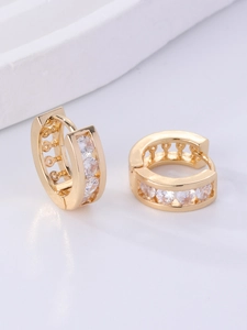 Close-up of gold huggie earrings featuring channel-set sparkling round zircons