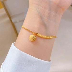 Bracciale in acciaio al titanio dorato con ciondolo sorriso e barra incisa sul polso