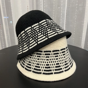 Detail shot of black and beige knit bucket hats featuring geometric jacquard patterns