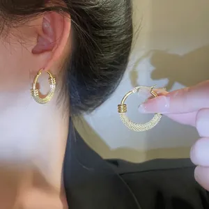 Golden titanium steel wide woven textured hoop earrings for women with a vintage retro design