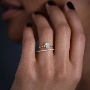 Close-up of luxury gold-plated square-cut diamond stacking rings worn by a model