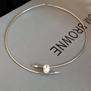 Detailed view of silver choker with oval crystal and arrow-shaped ends on display