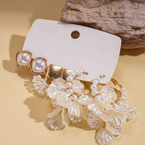 Elegant square pearl earrings with rhinestones and white petal tassels on a stone base