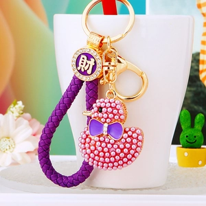 Detail of pink pearl duck keychain with purple braided leather strap and rhinestone charm