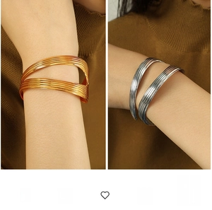 Detailed view of layered 18K gold and silver plated titanium steel textured bangles