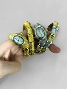 Detail of snake-shaped wrap bracelet watch in gold and silver finishes with quartz dial