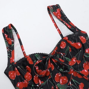 Detail of cherry print dress with black scalloped lace trim and bow neckline decoration