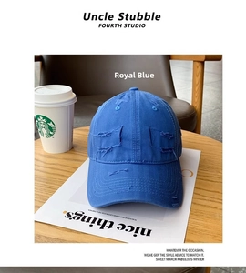 Royal blue distressed cotton baseball cap with vintage ripped details on a wooden surface