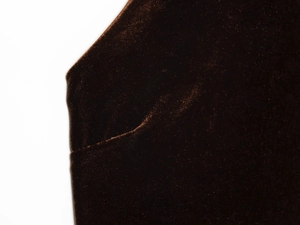 Détail de la texture en velours marron et des coutures de la robe dos nu à franges