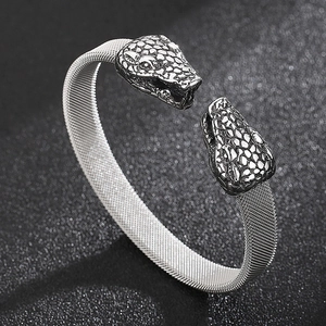 Macro shot of silver stainless steel snake head bracelet with woven Milanese mesh band