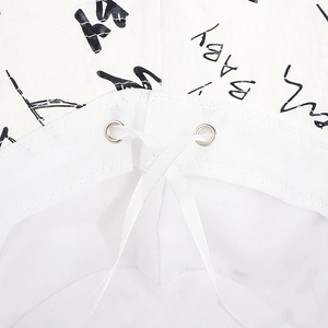 Detail of white canvas bucket hat featuring baby graffiti print and metal eyelets with cord