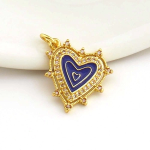 Close-up of heart-shaped gold-plated pendant with blue enamel and micro-set zircon crystals