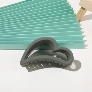 Detail view of heart-shaped dark grey hair claw clip with matte finish and non-slip teeth